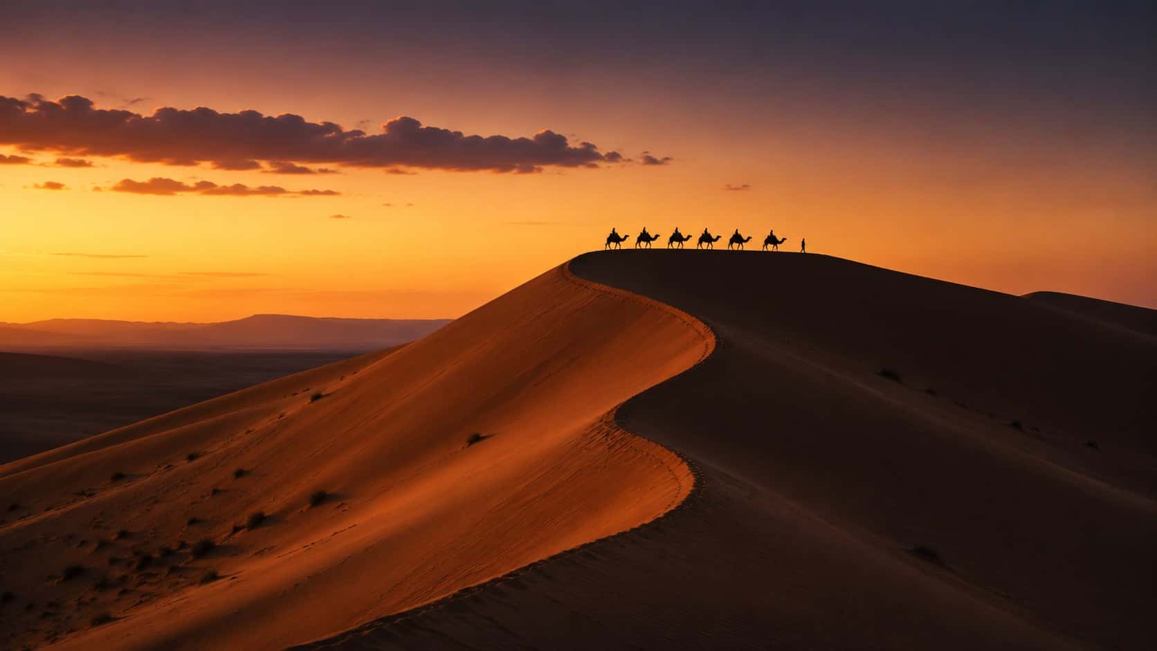 La cresta delle dune dell'Erg Chebbi nell'ultima luce, una carovana in lontananza